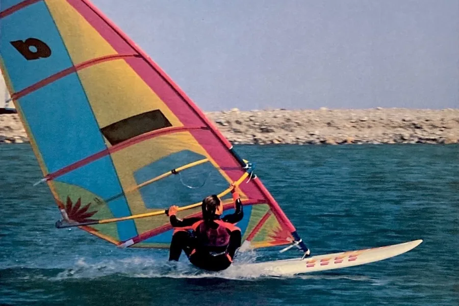 Vintage windsurfplank met kleurrijk zeil uit de jaren tachtig