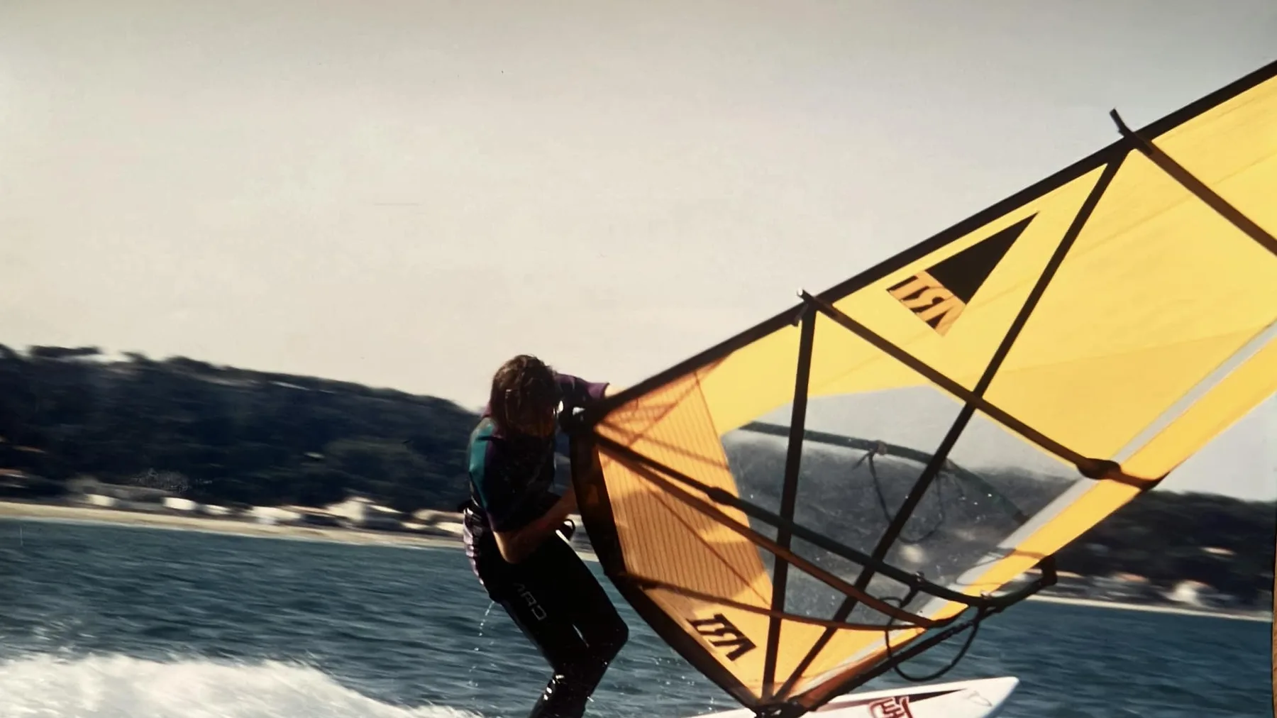 Windsurfer maakt een gijp onder een dramatische wolkenlucht