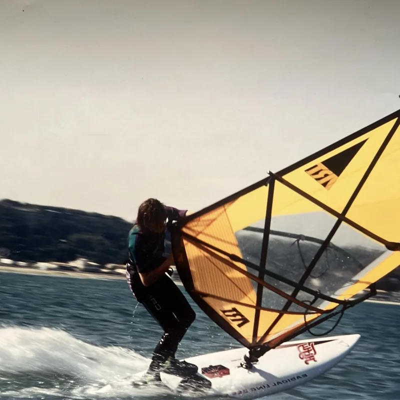 Windsurfer maakt een gijp op een oude plank
